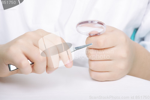 Image of Researchers hands with magnifier and tweezers