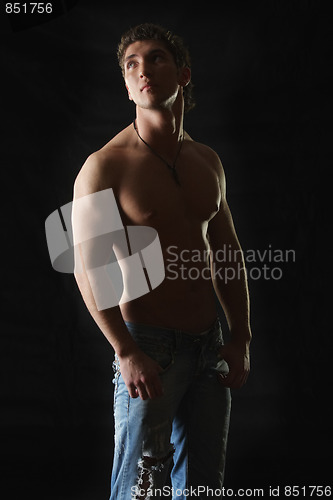 Image of Young man in jeans looking up