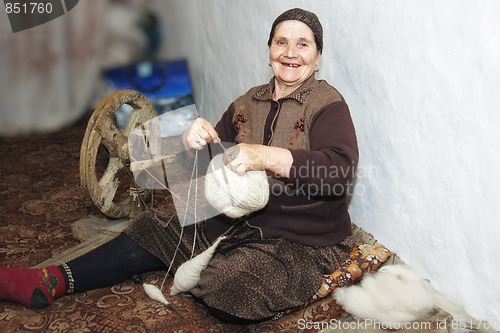 Image of Smiling senior winding up thread into clew