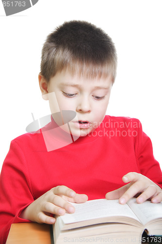 Image of Boy in red reading book at desk