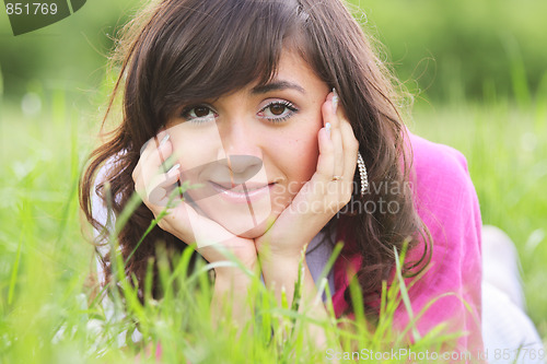 Image of Brunette in grass leaning on hands