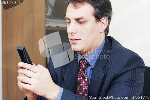 Image of Businessman holding cordless phone