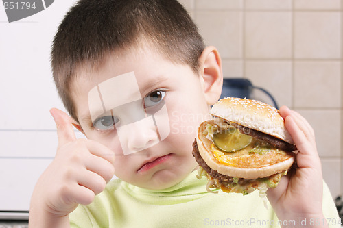 Image of Serious boy with hamburger