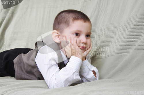 Image of Little boy laying on sofa