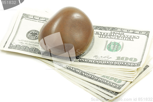 Image of Bundle of dollars under stone