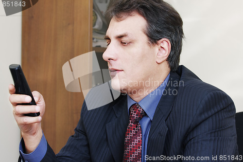 Image of Businessman dialing number on phone