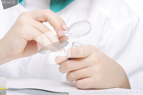 Image of Researchers hands with magnifying glass