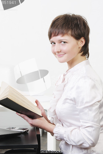 Image of Businesswoman at desk with book