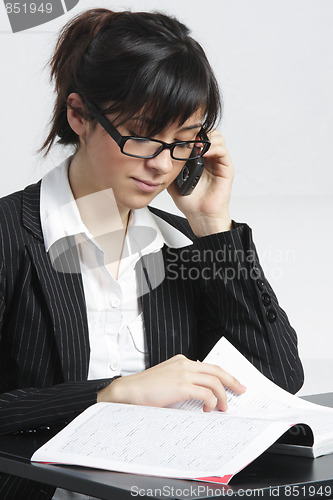 Image of Brunette businesswoman reading magazine
