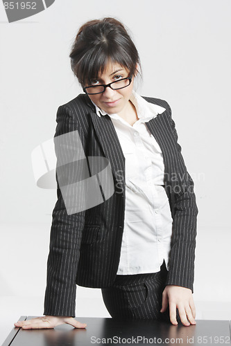 Image of Brunette businesswoman looking over glasses