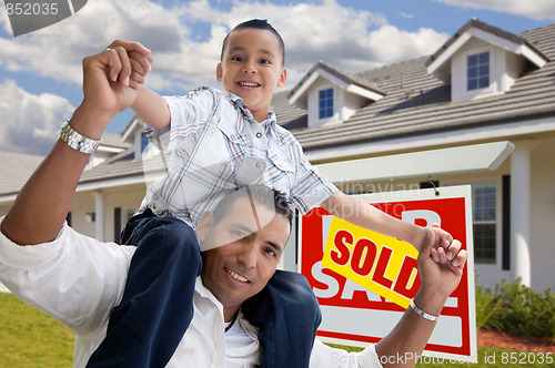 Image of Hispanic Father and Son with Sold Real Estate Sign