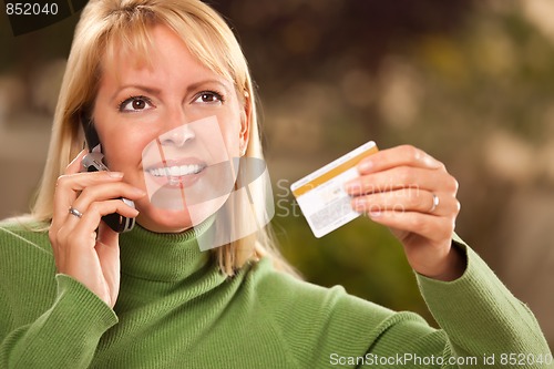 Image of Cheerful Woman Using Her Phone with Credit Card