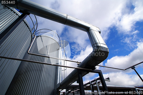 Image of industrial piping and tanks against blue sky