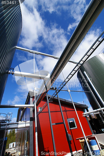 Image of industrial piping and tanks against blue sky