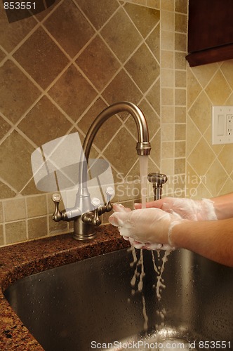 Image of Hand washing and rinsing soapy water at a sink