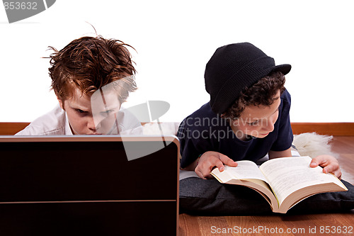 Image of children playing computer and reading a book