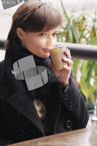 Image of Woman in black coat with cup