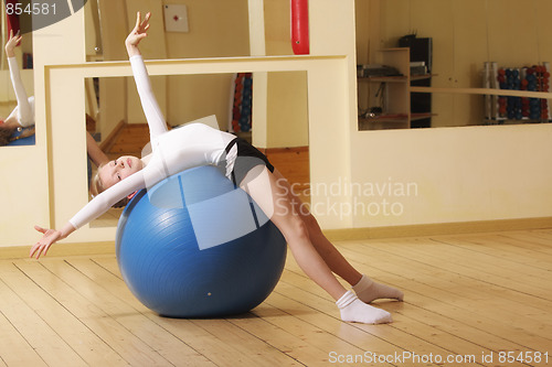 Image of Little gymnast laying on ball