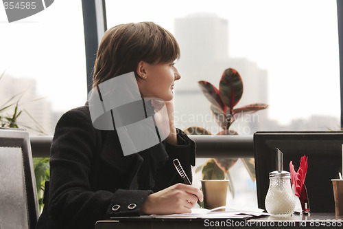 Image of Pensive woman in black working in cafe