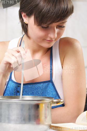 Image of Cute woman using cookbook