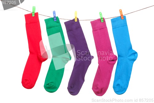 Image of five different color socks hang on rope