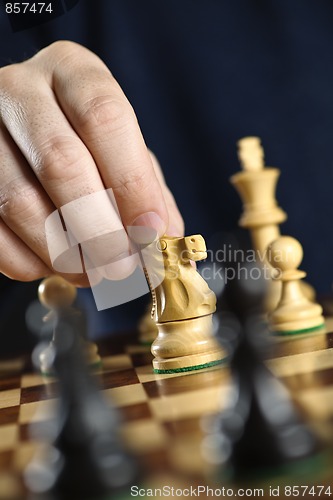 Image of Hand moving knight on chess board