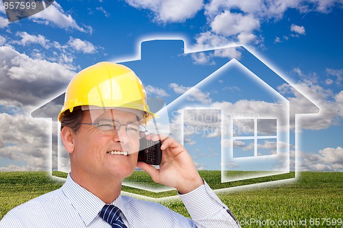 Image of Contractor in Hardhat on Phone Over House, Grass and Clouds