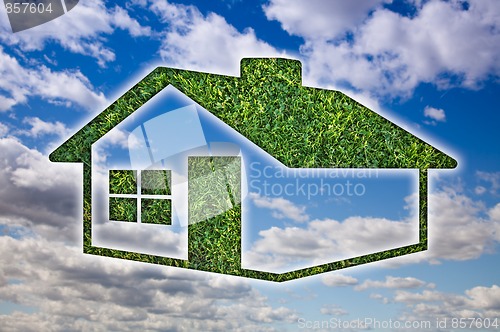 Image of Green Grass House Icon over Sky and Clouds