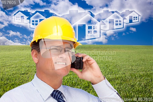 Image of Contractor in Hardhat on Phone Over House, Grass and Clouds
