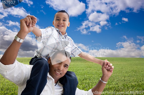 Image of Father and Son Over Grass Field, Clouds and Sky