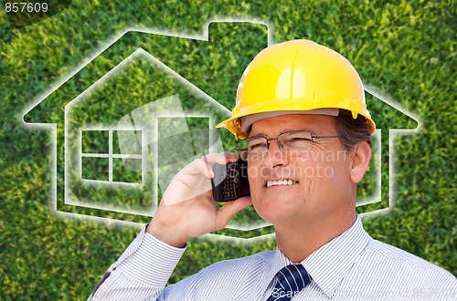 Image of Contractor in Hardhat on Cell Phone Over House Icon and Grass