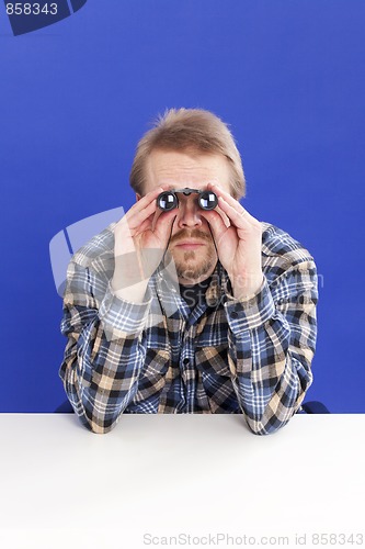 Image of Man watches with binoculars