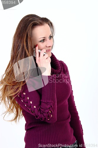 Image of The attractive woman talks by a mobile phone on a white background 