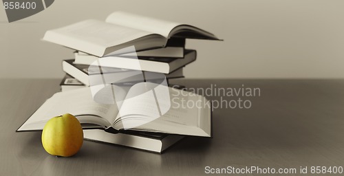 Image of green apple and opened books 