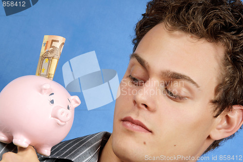 Image of Young man with piggy bank