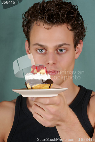 Image of Young man with cupcake