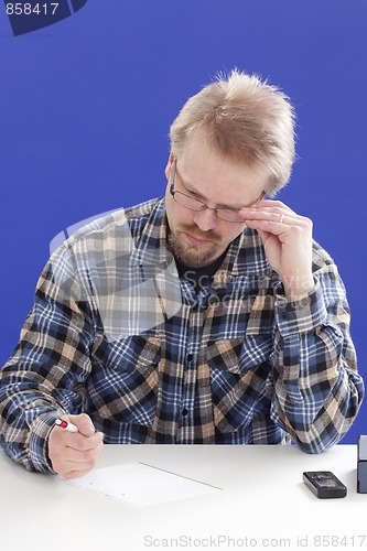 Image of Man writes notes at his office desk