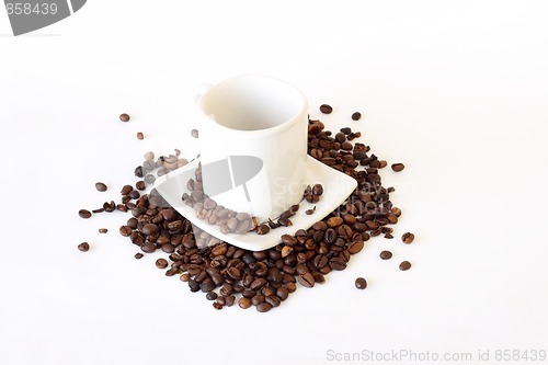 Image of coffee mug spoon with spilled coffee on white 