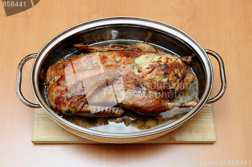 Image of Roasted duck in pan on the wooden desk