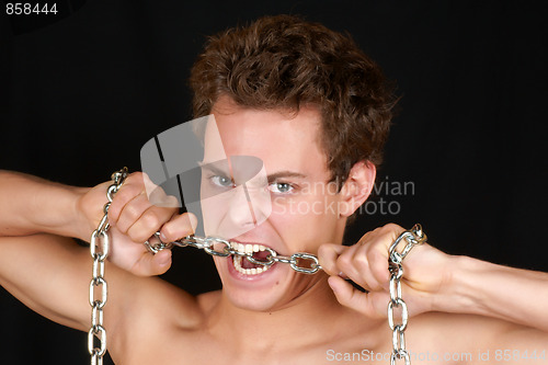 Image of Young man biting a chain