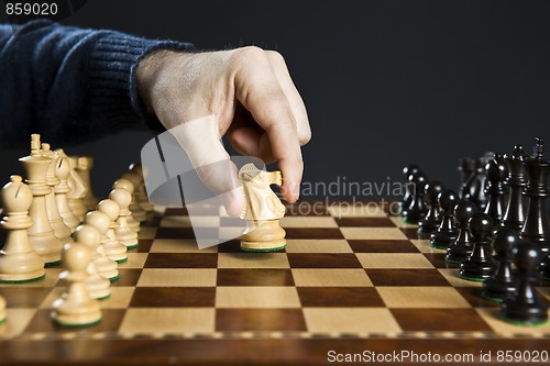 Image of Hand moving knight on chess board