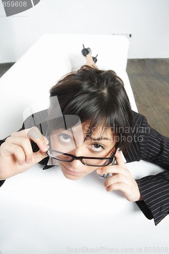 Image of Brunette businesswoman looking over spectacles