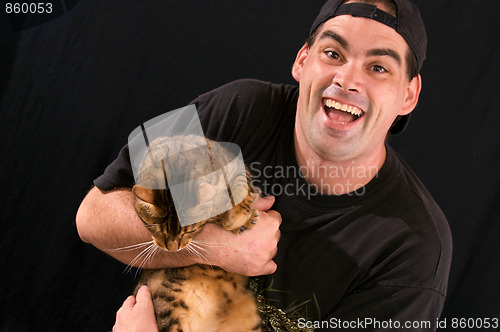 Image of man with crazed look holding cat