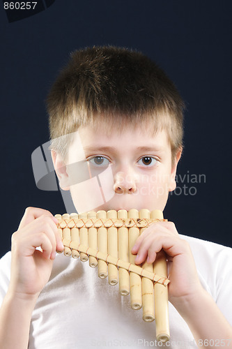 Image of Boy in white playing panflute