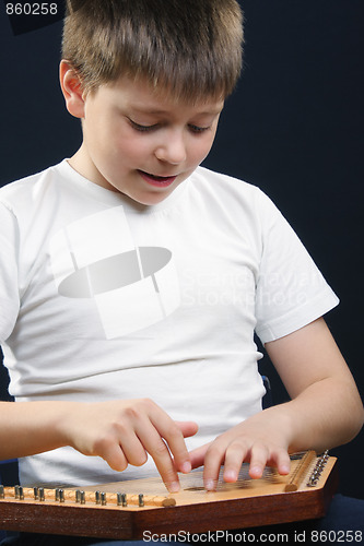 Image of Boy in white playing gusli