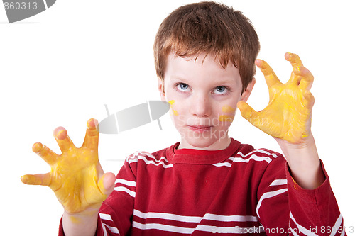 Image of Kid playing with yellow paint