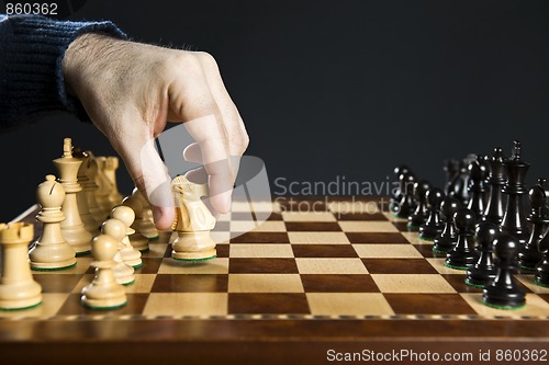 Image of Hand moving knight on chess board