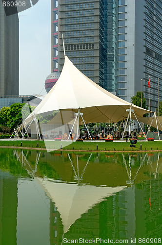 Image of Reflection of skyscrapers and tent over lake