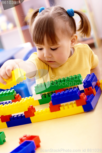 Image of Little girl play with building bricks in preschool