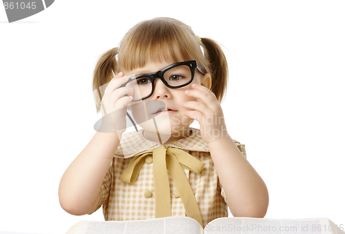Image of Happy little girl with book wearing black glasses